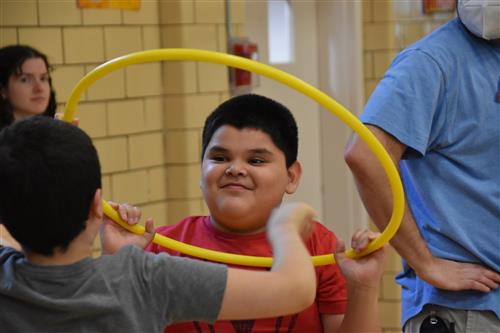 Kids playing with hula hoop.